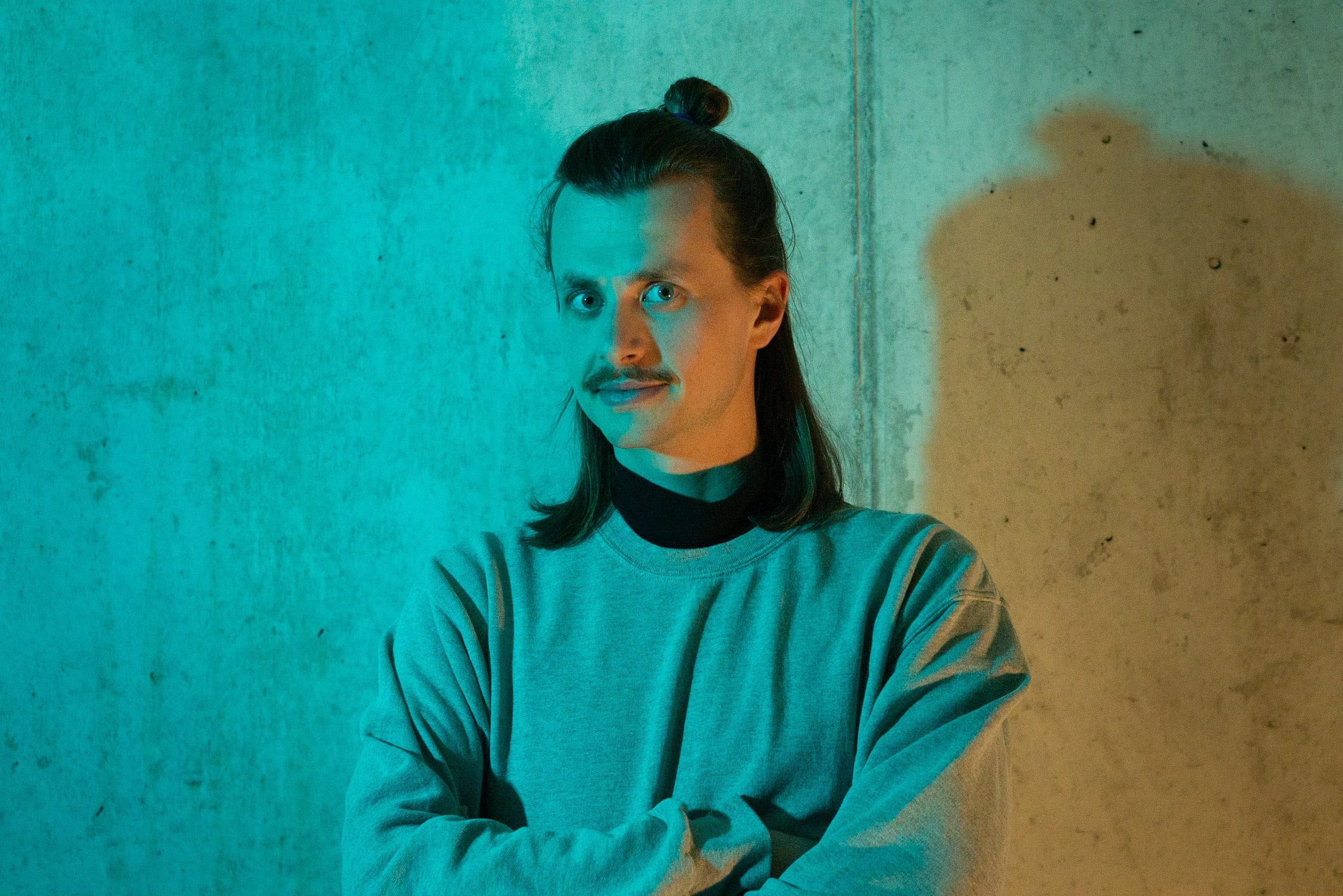 me in front of a concrete wall with two different light sources from the left in bluish light and from the right in yellowish light